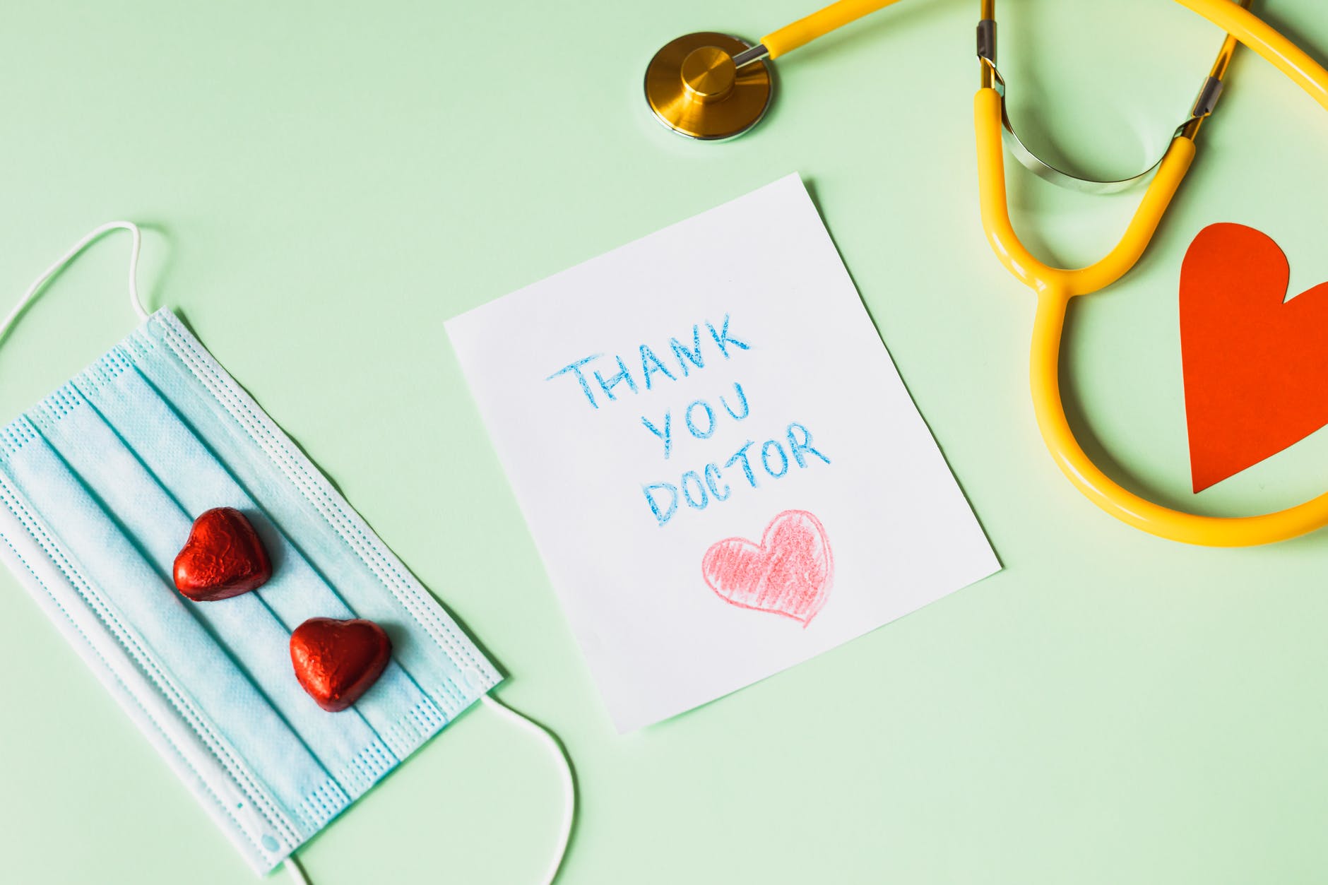 thank you doctors note next to a face mask and a stethoscope